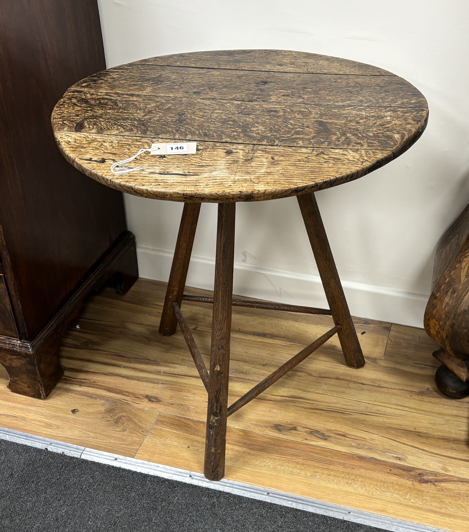 A circular oak cricket table, diameter 65cm, height 69cm